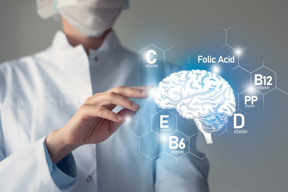 A healthcare professional in a white coat interacts with a digital display showing a brain and various vitamins, including folic acid, highlighting their importance for brain health.