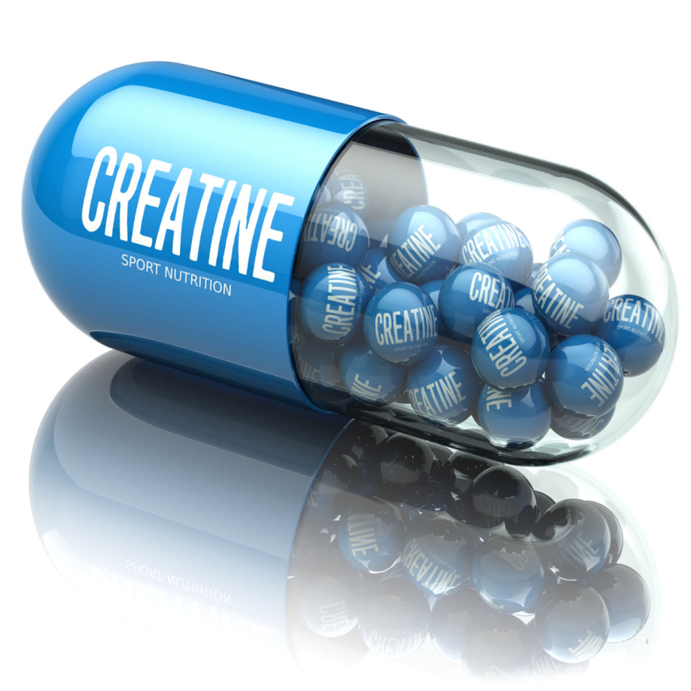 A large blue capsule labeled "CREATINE" contains smaller blue balls with the same label, resting on a reflective surface, emphasizing its use in sport nutrition.