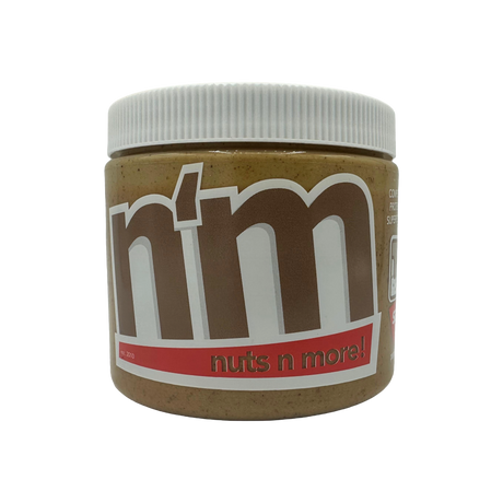 A close-up of a jar of "Nuts n More" nut butter, featuring a white lid and a label with bold brown and red text, set against a black background.