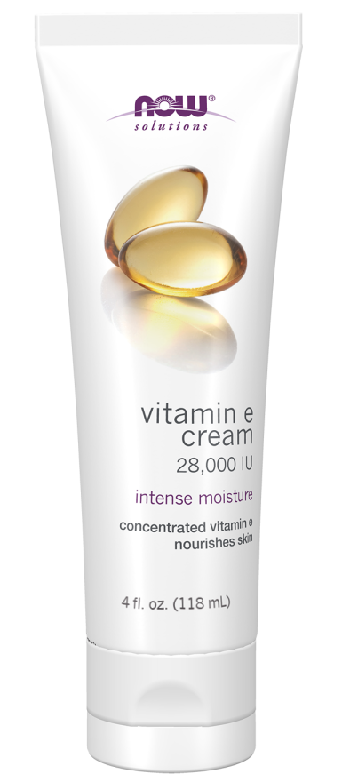 A white tube of NOW Solutions Vitamin E cream, labeled "28,000 IU" and "intense moisture," features soft gel capsules on the front, indicating concentrated vitamin E for skin nourishment.
