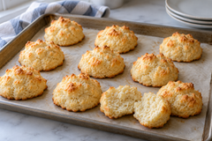 Small golden Bakesquick drop biscuits on a baking sheet.
