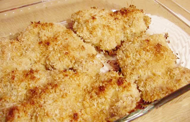 Golden-brown, crispy baked chicken fillets are arranged neatly in a glass dish, showcasing a crunchy panko coating and a light, appetizing texture.
