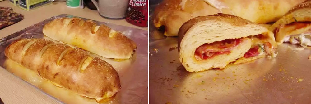 Two golden-brown loaves of bread are displayed on a baking sheet, one whole with slits on top, and the other sliced open to reveal layers of meat and cheese inside.