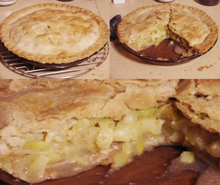 A freshly baked apple pie sits on a cooling rack, with a slice removed to reveal the soft, baked apple filling and flaky crust, set on a wooden table with kitchen items in the background.