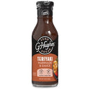 A clear glass bottle of G. Hughes Zero Sugar Teriyaki Marinade and Sauce, featuring a black and orange label with nutritional information, is displayed against a white background.