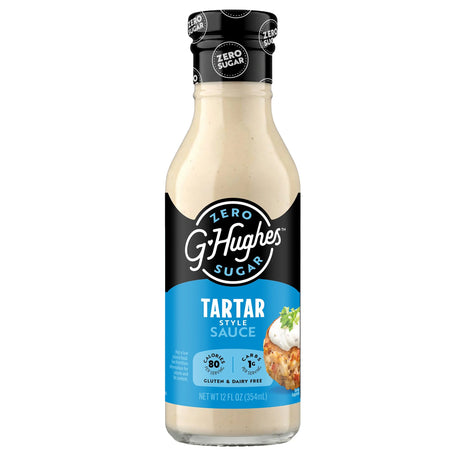 A clear bottle of G. Hughes Zero Sugar Tartar Style Sauce, featuring a black and blue label, sits upright, displaying its 12 fl oz volume and highlighting that it is gluten and dairy-free.