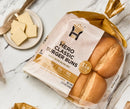 A package of Hero Classic Burger Buns, made with olive oil, sits on a marble surface next to a plate of butter, highlighting the product's nutritional information and serving size.