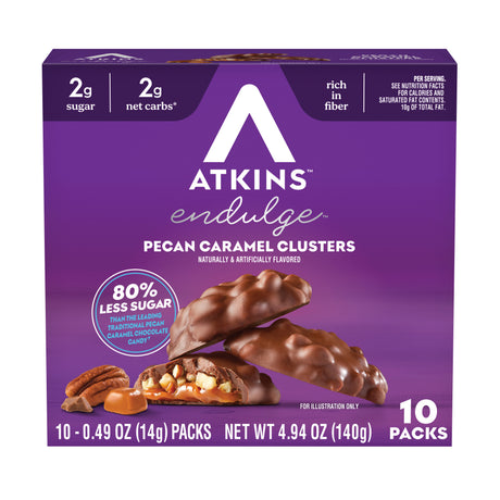 A purple box of Atkins Endulge Pecan Caramel Clusters displays the product name and nutritional information, with chocolate-covered clusters and pecans shown alongside the box.