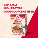 A box of Atkins Whipped High Protein Bars in Chocolate Malt flavor, featuring two bars partially unwrapped, highlights key benefits like high protein, low sugar, and being a good source of fiber.