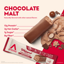 A chocolate malt protein bar is displayed alongside chocolate swirls and pieces, with nutritional information highlighting 13g protein, 2g net carbs, 1g sugar, and 8g fiber.