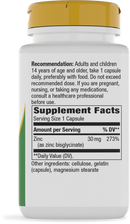 A white supplement bottle with a yellow cap displays the label, listing dosage recommendations, serving size, and nutritional information for zinc capsules.