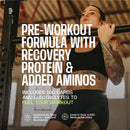 A focused woman with tattoos performs a pull-up in a gym, showcasing a pre-workout formula that includes recovery protein and electrolytes for enhanced performance.