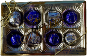 A gold box tied with a ribbon contains eight sugar-free cherry cordials, each wrapped in shiny blue foil, showcasing a premium chocolate gift suitable for special occasions.