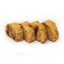 Four rectangular pieces of golden-brown, crumbly dessert are arranged in a row on a white background, showcasing a texture that appears moist and inviting, with visible bits of nuts.