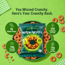 A green background features a bag of Crisp Power Protein Pretzels, highlighting nutritional facts, surrounded by pretzels on a plate, with text promoting low sugar and high protein content.
