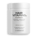 A white container labeled "HAIR VITAMINS. PLATINUM" with details about ingredients like Lustriva, Spermidine, Collagen, and Keratin, indicating it contains 90 vegetable capsules as a dietary supplement.
