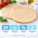 Two thin pizza crusts are placed on a marble countertop, surrounded by fresh tomatoes, basil, and a bowl of cheese, with nutritional information displayed below.