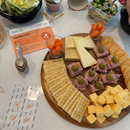 Platter of assorted cheeses, meats, and crackers on a table with a 'PediaSure' product card.