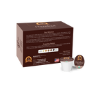 A brown coffee box labeled "Hazelnut" displays a mission statement and cupping notes, alongside a single serve coffee pod, emphasizing organic and low-acid features for sensitive drinkers.