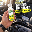 A person holds a bottle of lemon-lime protein shot in a car, with a backpack and water bottle visible in the background, emphasizing convenience for those who missed a traditional shake.