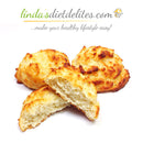Three golden-brown, fluffy biscuits are arranged on a white background, with one biscuit cut in half to show its soft interior, suggesting a delicious, healthy treat.