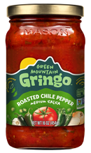 A glass jar of Green Mountain Gringo Roasted Chile Pepper medium salsa, featuring vibrant red salsa with visible ingredients like tomatoes and peppers, labeled with product details and a gold lid.