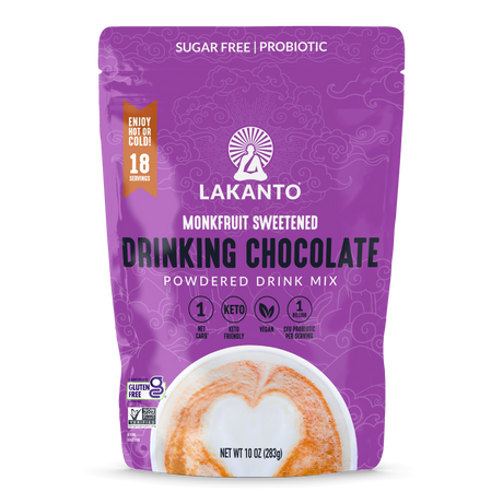 A purple package of Lakanto Monkfruit Sweetened Drinking Chocolate powder features the product name prominently, highlighting it's sugar-free, keto-friendly, and vegan, with 18 servings per bag.