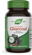 A dark brown bottle of Nature's Way Activated Charcoal dietary supplement, featuring a green cap, displays information about reducing occasional gas and contains 100 capsules, each with 560 mg per serving.