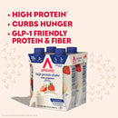 A six-pack of Atkins high protein strawberry shakes is displayed, highlighting benefits like high protein, hunger control, and GLP-1 friendly ingredients on a light pink background.