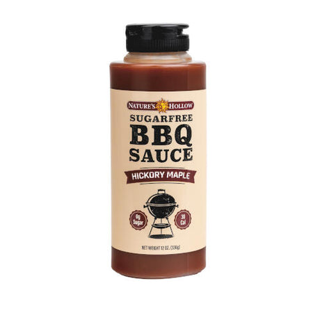 A bottle of Nature's Hollow sugar-free hickory maple BBQ sauce, featuring a label with bold text, a grill graphic, and nutritional information, set against a plain background.