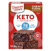 A box of Duncan Hines Keto Friendly Chewy Fudge Brownie Mix features two stacked brownies, highlighting gluten-free and low-carb benefits with a red and white design.