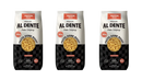 Three bags of Al Dente protein pasta are displayed, each featuring a clear window showing the cavatappi pasta inside, with labels highlighting "30g protein" and "Pasta Done Right."