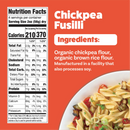 A colorful plate of chickpea fusilli pasta mixed with vegetables sits beside a nutrition facts label detailing ingredients and serving information, highlighting organic chickpea and brown rice flour.