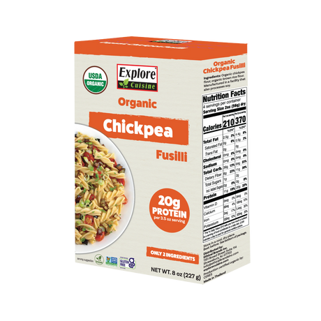 A box of Explore Cuisine Organic Chickpea Fusilli features a colorful pasta dish on the front, highlighting its 20 grams of protein per serving and listing nutrition facts on the side.