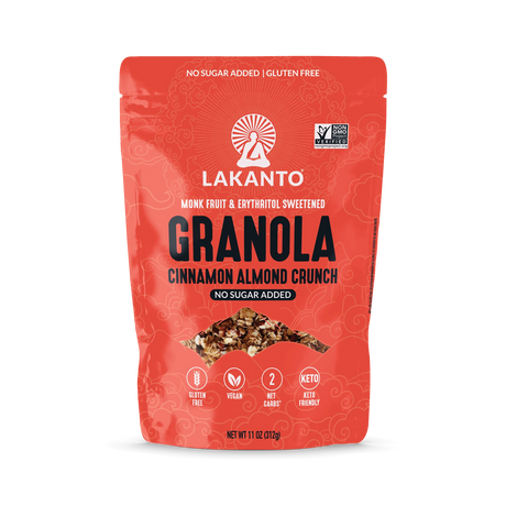 A bright red bag of Lakanto Cinnamon Almond Crunch granola features bold text highlighting it is gluten-free, vegan, and sweetened with monk fruit and erythritol, with no added sugar.