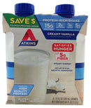 A carton of Atkins Creamy Vanilla protein-rich shakes features a glass filled with a creamy beverage, highlighting nutritional benefits like 15g protein, 5g fiber, and a coupon offer.