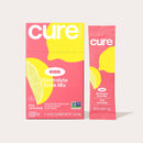 A pink and yellow box of Cure Kids Electrolyte Drink Mix, featuring a lemon graphic, displays six packets labeled "Pink Lemonade," emphasizing it's pediatrician formulated and plant-based.