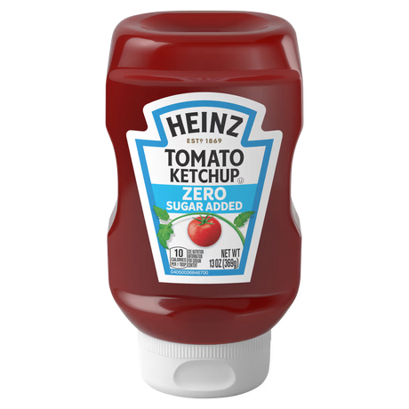 A bottle of Heinz Tomato Ketchup labeled "Zero Sugar Added," featuring a red design, green leaves, and a tomato graphic, stands upright against a plain background.