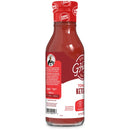 A clear glass bottle of G Hughes zero sugar tomato ketchup stands upright, showcasing its red contents and labeled with nutritional information and branding details.