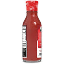 A glass bottle of zero-sugar ketchup is shown, featuring a red label with nutritional information and a logo, positioned against a plain background.