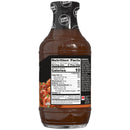 A transparent bottle of zero sugar barbecue sauce displays nutrition facts and ingredients on its label, alongside a serving suggestion featuring glazed meat.
