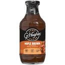 A clear bottle of G. Hughes Maple Brown flavored BBQ sauce, labeled as zero sugar, featuring a black and orange design with nutritional information, sits against a plain background.