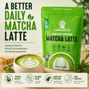 A green packet of Lakanto Monk Fruit Sweetened Matcha Latte powder is displayed next to a bowl of matcha latte with a leaf design, highlighting its sugar-free and probiotic benefits.