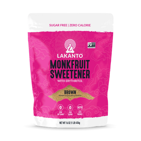 A bright pink package of Lakanto Monkfruit Sweetener with Erythritol, labeled as "Brown" and featuring icons for zero net carbs and keto-friendly, is displayed against a plain background.
