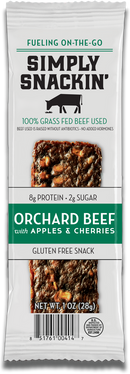 A packaged snack bar labeled "Simply Snackin' Orchard Beef with Apples & Cherries," highlighting its gluten-free, high-protein content and made from 100% grass-fed beef.