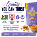 A purple package of Lakanto Peanut Butter Powder is displayed with icons indicating it's non-GMO, gluten-free, and vegan, alongside a bowl of peanut butter and peanuts, emphasizing quality and health benefits.