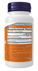 A white supplement bottle with a purple cap displays the label detailing ingredients and nutritional information, highlighting GABA and magnesium content for dietary use.