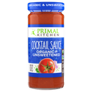 A clear glass jar of Primal Kitchen organic and unsweetened cocktail sauce features a vibrant red sauce with a tomato graphic, labeled prominently in blue and green.