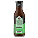 A brown bottle of zero-sugar sauce features a green label with text about the product and a photo of Guy Hughes, highlighting its bold flavors and versatility for cooking.