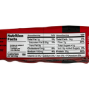 A nutrition facts label on a red package displays detailed information about serving size, calories, fats, carbohydrates, fiber, sugars, sodium, and protein content.